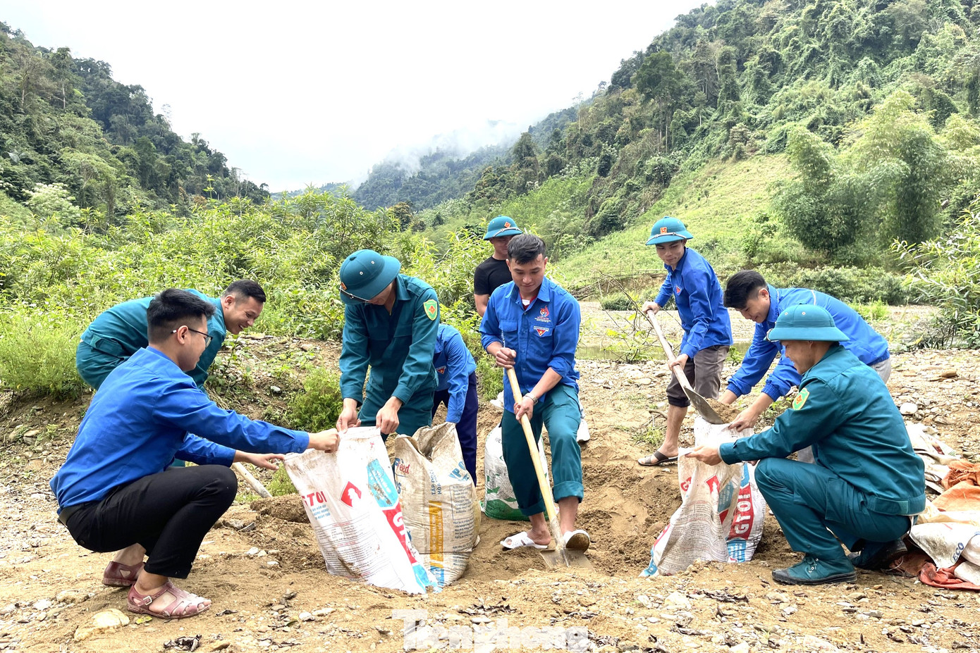 Đóng cát vận chuyển về địa điểm làm nhà hộ gia đình anh Lang Văn Điển. Ảnh: Thu Hiền