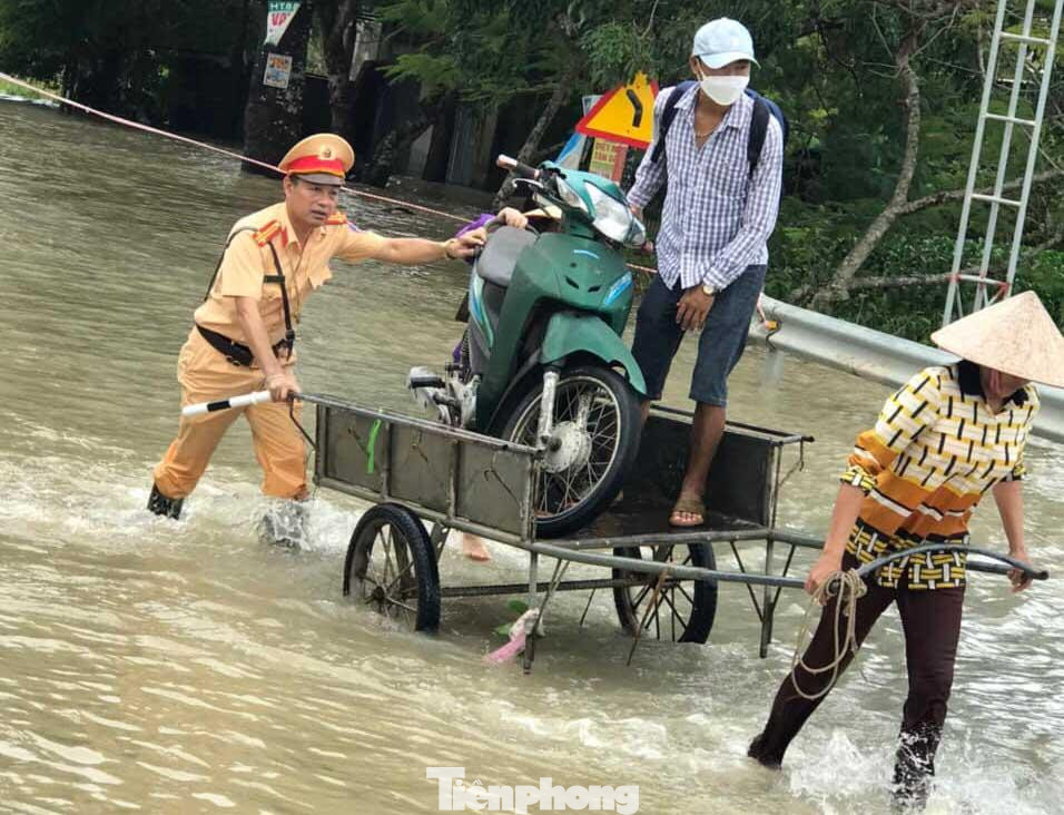 Công an giúp đỡ người dân và phương tiện di chuyển qua các tuyến đường bị ngập sâu