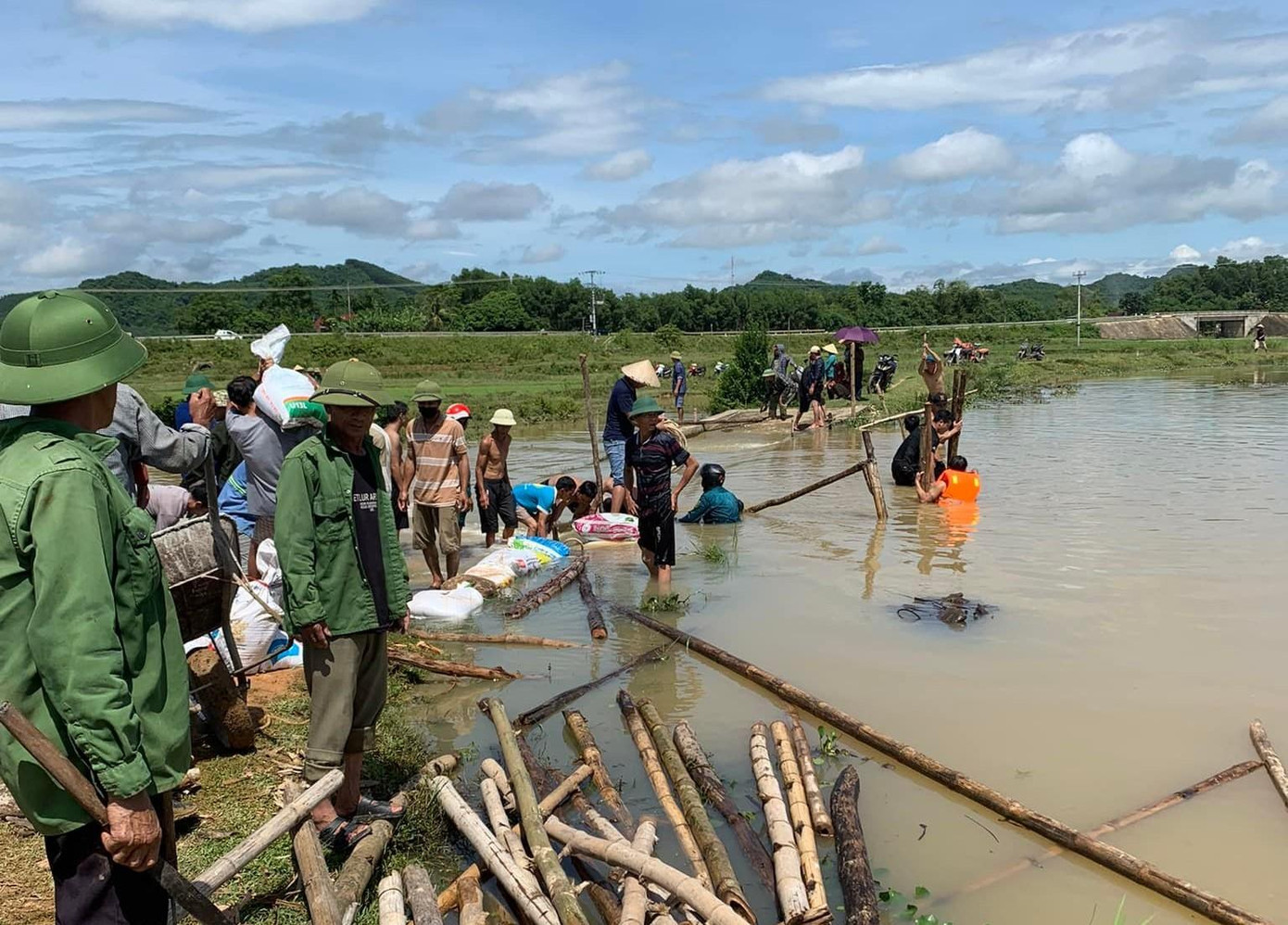 Sử dụng cọc tre, bao tải ngăn bớt dòng chảy trên đập tràn để tìm kiếm thi thể em H.