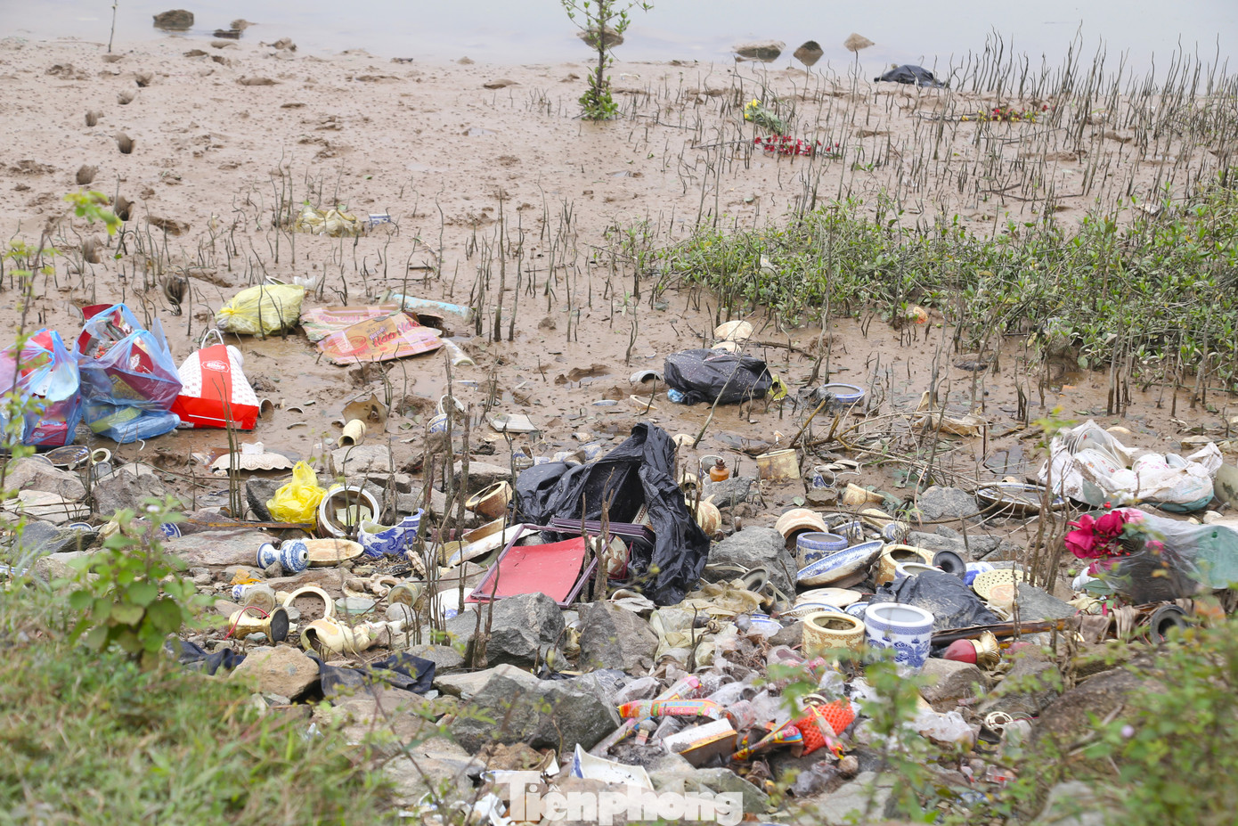 Bát hương, bàn thờ bị vứt bỏ bên mép sông.