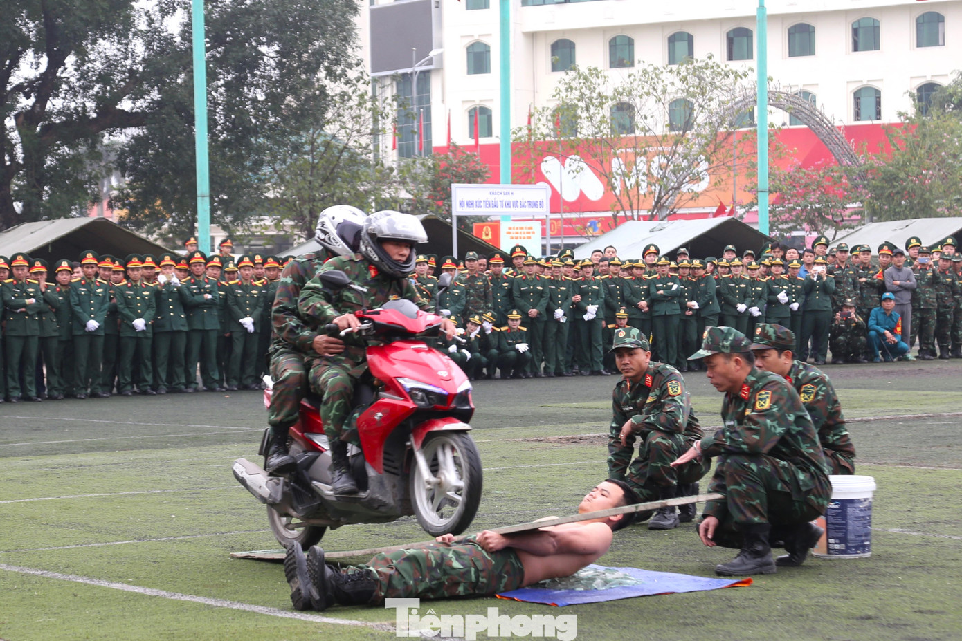 Cho xe máy chạy trên tấm ván qua người trần nằm trên mảnh thủy tinh vỡ.