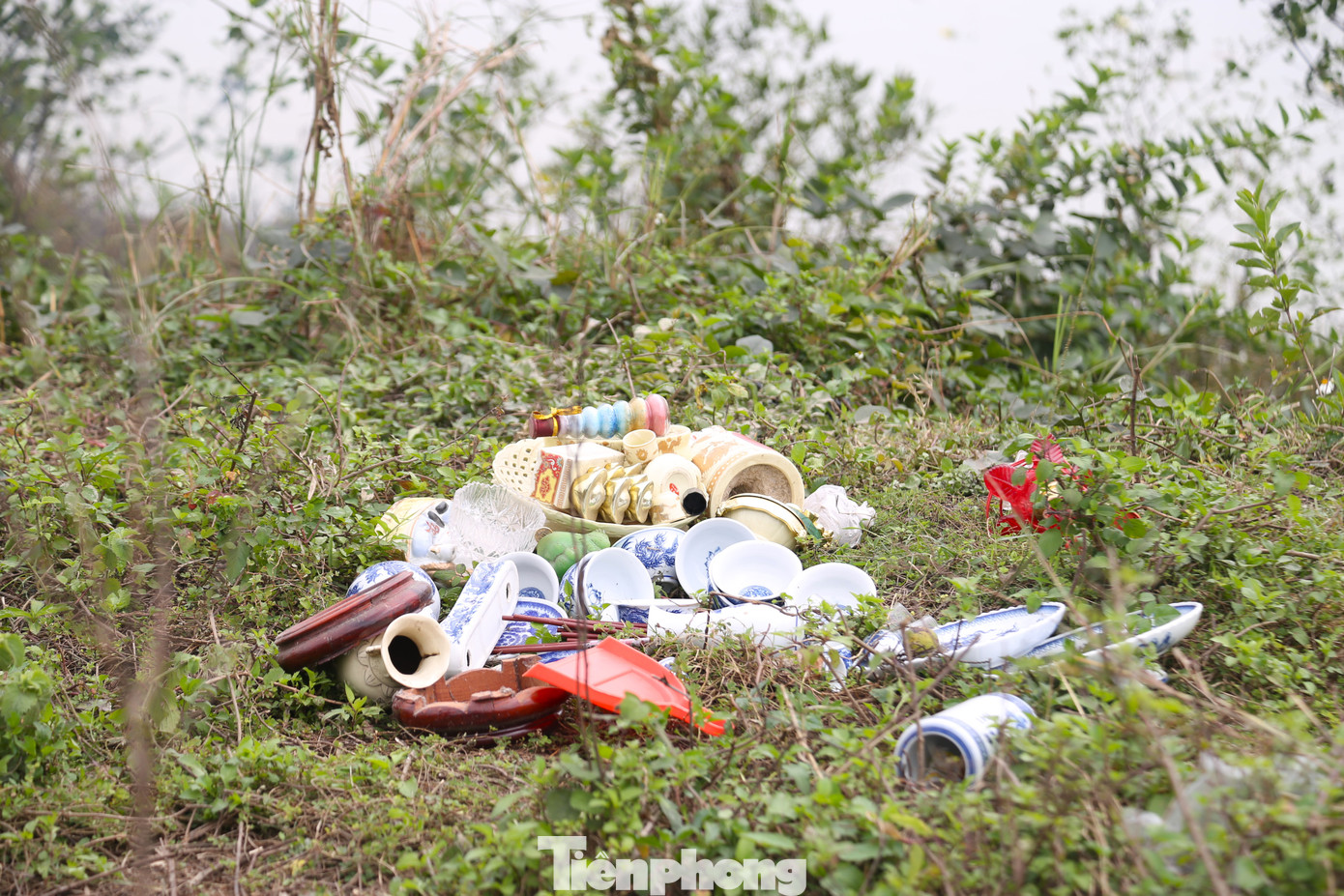 Một số người khác mang túi ni lông lên bờ để đốt, gây ô nhiễm môi trường. Trên bờ, ngập rác thải, đồ thờ cúng do người dân để lại.