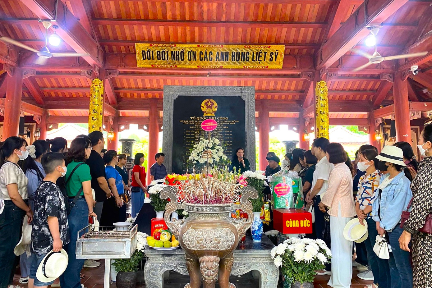 Bên ngôi mộ chung, du khách lắng lòng nghe thuyết minh viên kể lại giây phút hy sinh đầy xúc động của 13 liệt sĩ thanh niên xung phong.