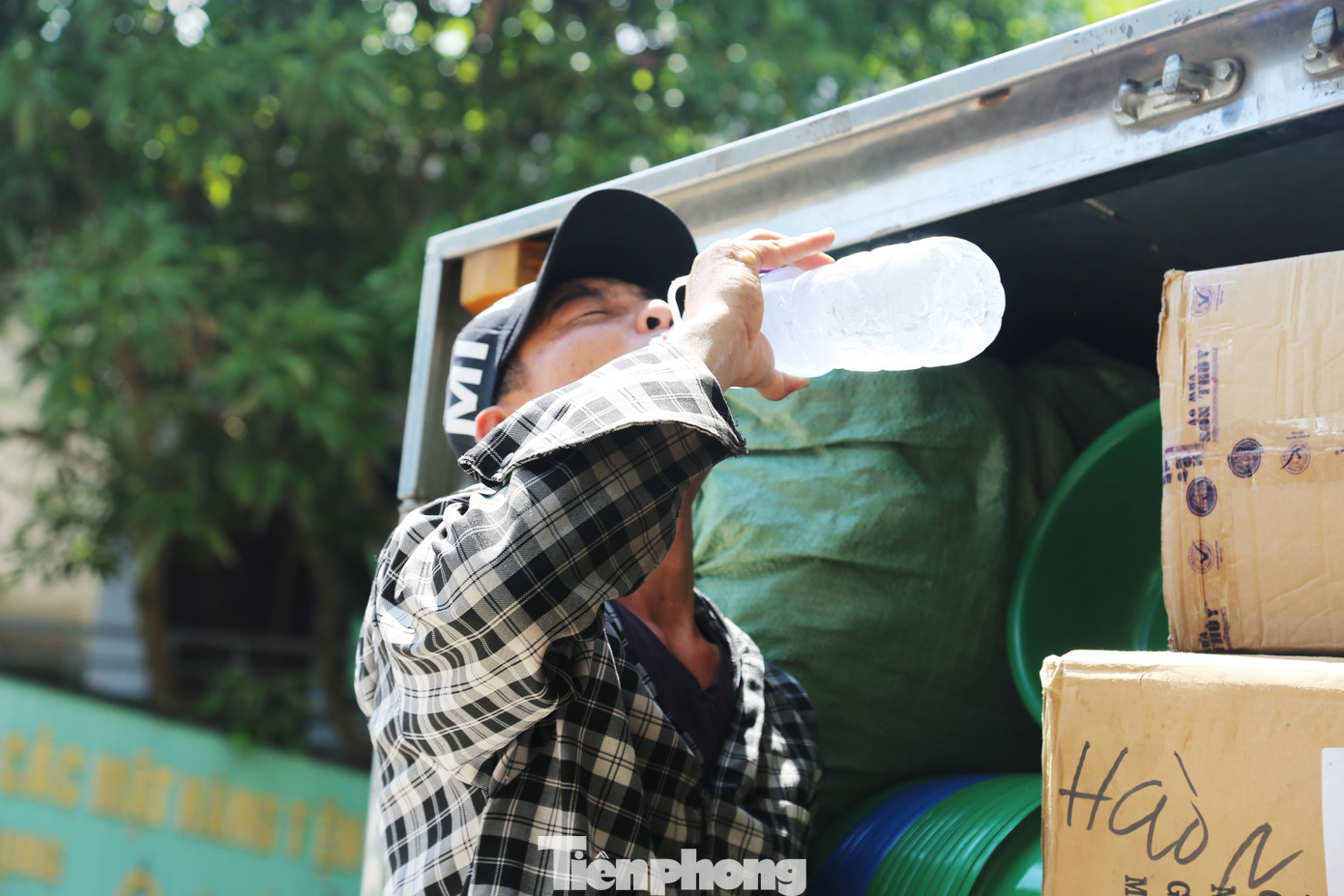 Để chống chọi với cái nắng gay gắt của mùa hè, ngoài mũ áo, anh Thức còn kèm theo một chai nước lọc 1,5 lít để uống những lúc mất sức.