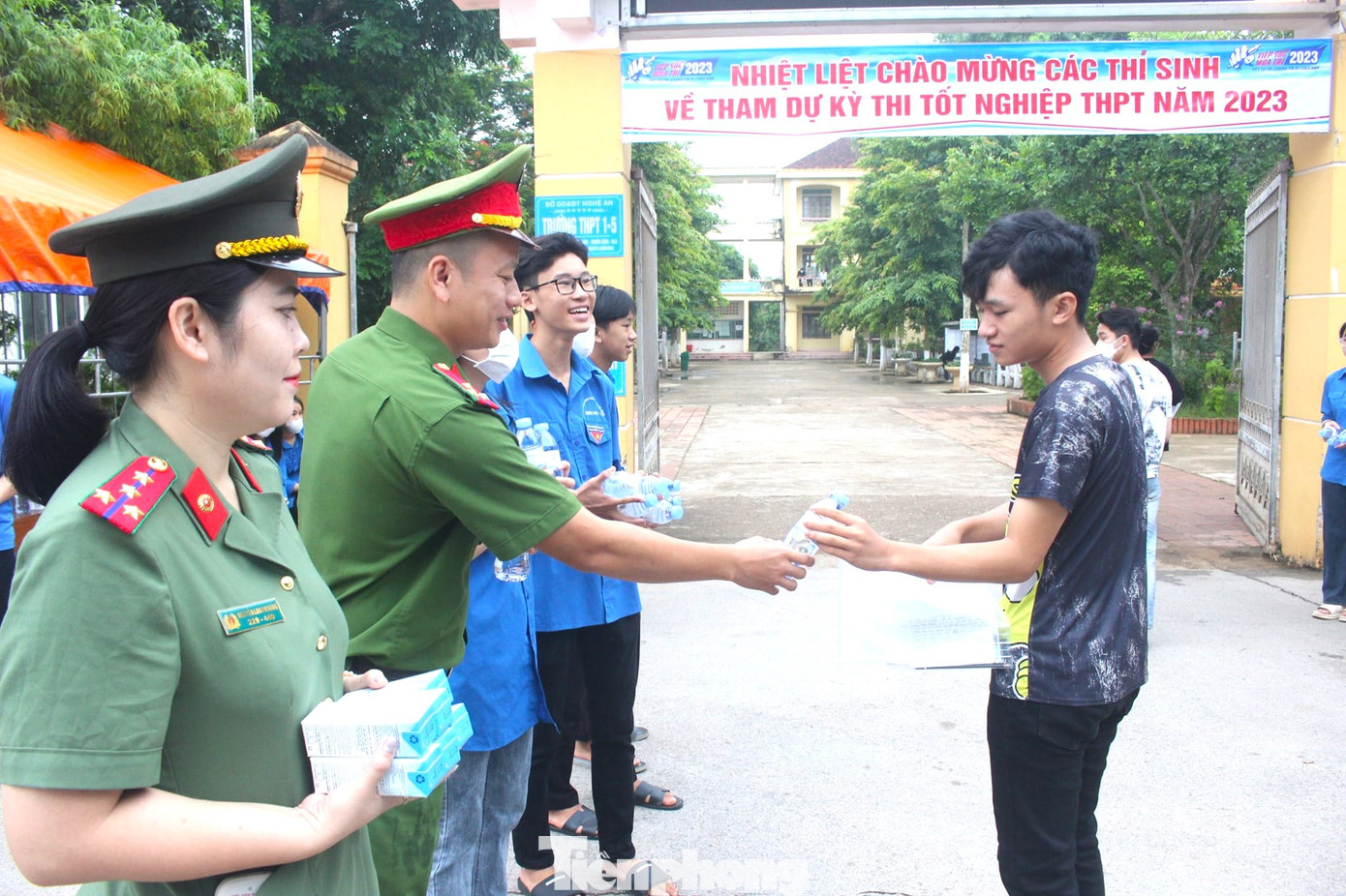 Phía ngoài cổng trường, các cán bộ, chiến sĩ phát nước uống, sữa, các đồ dùng học tập hỗ trợ cho thí sinh trước khi vào thi.