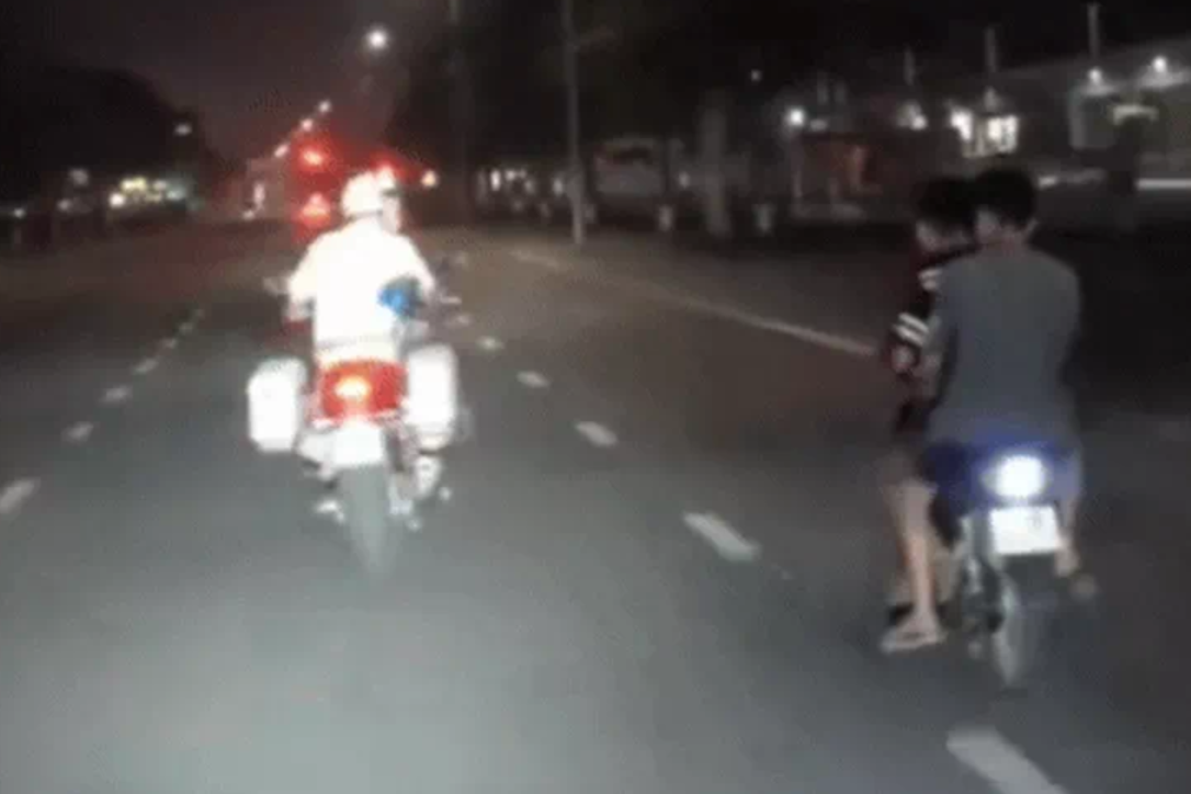 Xe máy kẹp 3 lạng lách, đánh võng, thách thức cảnh sát giao thông. Ảnh cắt từ video Xe máy kẹp 3 lạng lách, đánh võng, thách thức cảnh sát giao thông. Ảnh cắt từ video