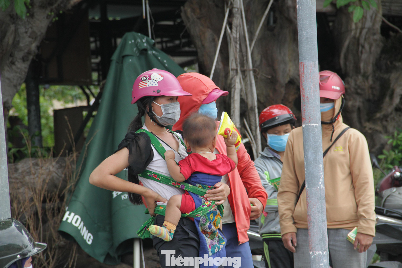 Nhiều trẻ nhỏ được mẹ địu hoặc buộc chăn vào bụng