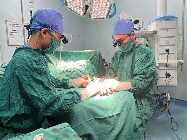 Các bác sĩ thực hiện phẫu thuật vi phẫu nối bàn tay đứt rời cho bệnh nhân