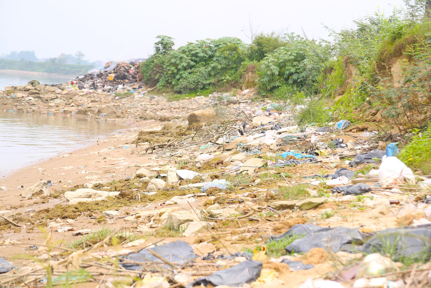 Dọc bờ sông Lam, dưới chân cầu Yên Xuân, rác thải tràn ngập.