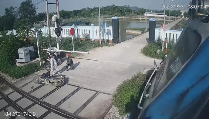 Chị Hường hét lớn và lao ra ngăn cản người đàn ông đang cố vượt qua đường sắt. Ảnh chụp toàn màn hình Chị Hường hét lớn và lao ra ngăn cản người đàn ông đang cố vượt qua đường sắt. Ảnh chụp toàn màn hình