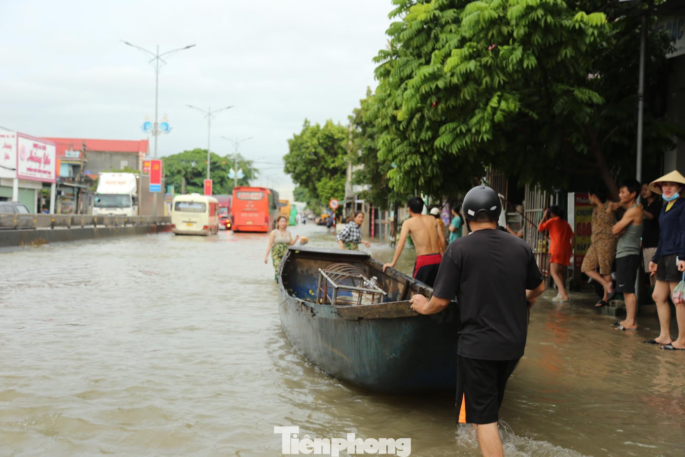 Người dân dùng thuyền di chuyển trên đường Quốc lộ.