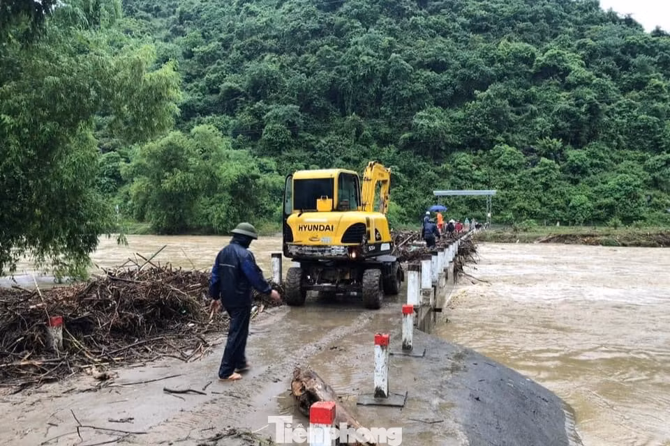 Lực lượng chức năng huy động máy móc để san gạt một số tuyến đường hư hỏng.