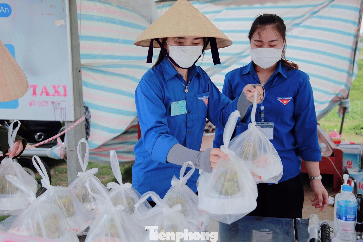 Nguyễn Thị Oanh (bên trái) mang những phần cơm đã chuẩn bị tiếp sức tuyến đầu chống dịch