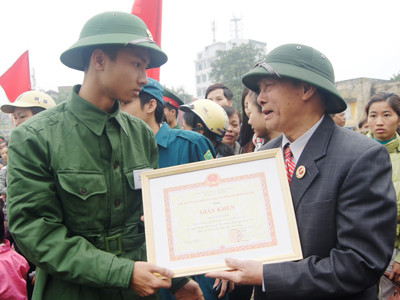 Cựu chiến binh Hoàng Văn Xuyên căn dặn cháu ngoại là tân binh Nguyễn Đức trước giờ lên đường tòng quân. Ảnh: Nguyễn Minh