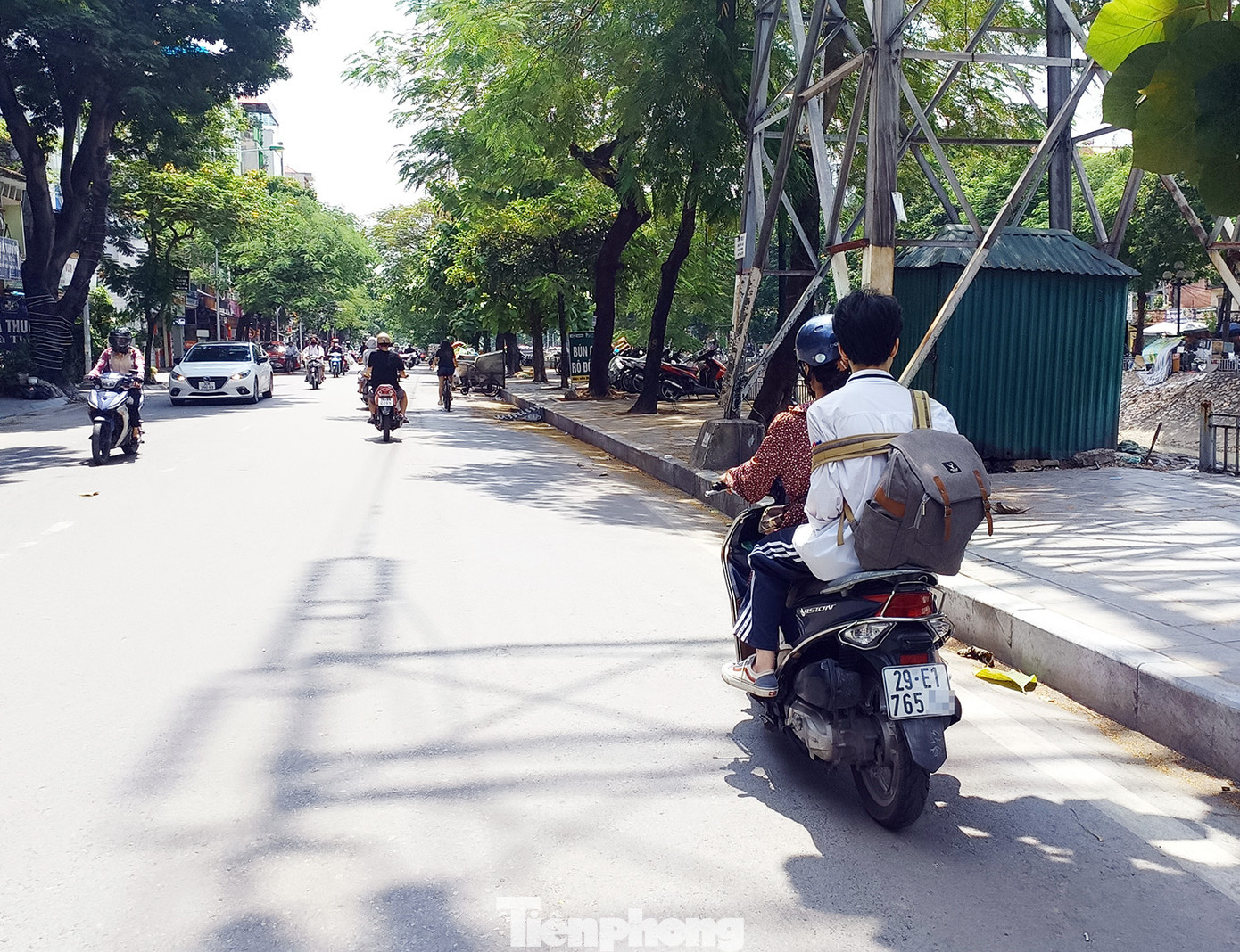 Một người lớn chở theo học sinh trên đường Kim Ngưu không đội mũ cho con em mình.
