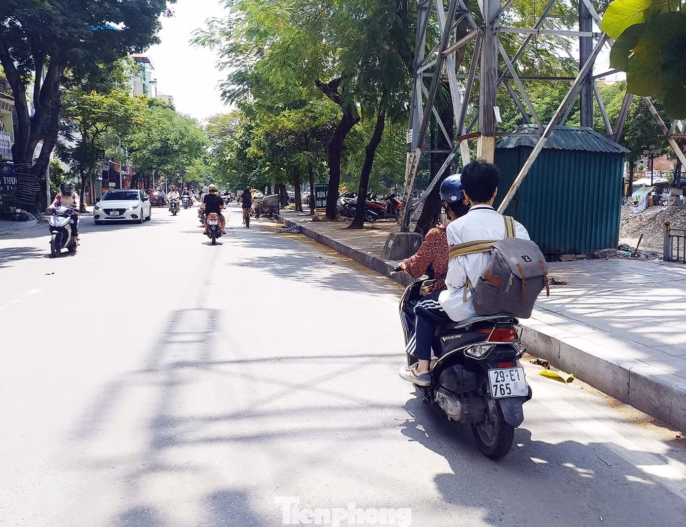 Một người lớn chở theo học sinh trên đường Kim Ngưu không đội mũ cho con em mình.