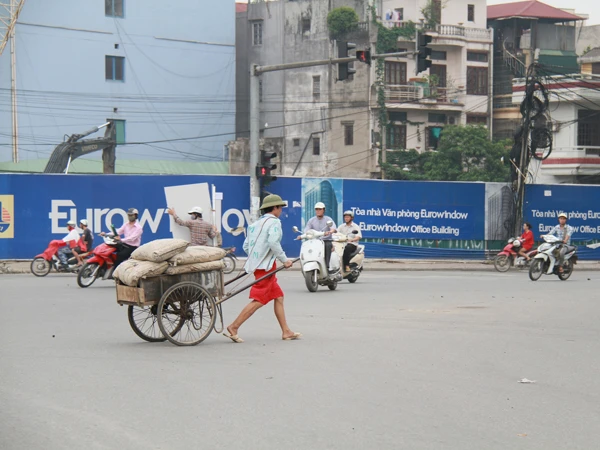 Hoàng Anh Việt kéo xe chở 6 bao xi măng. Ảnh: Trường Phong. Hoàng Anh Việt kéo xe chở 6 bao xi măng. Ảnh: Trường Phong