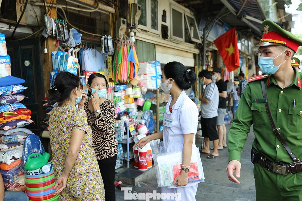 Nhân viên y tế phường nhắc nhở người dân đeo khẩu trang đúng quy định.