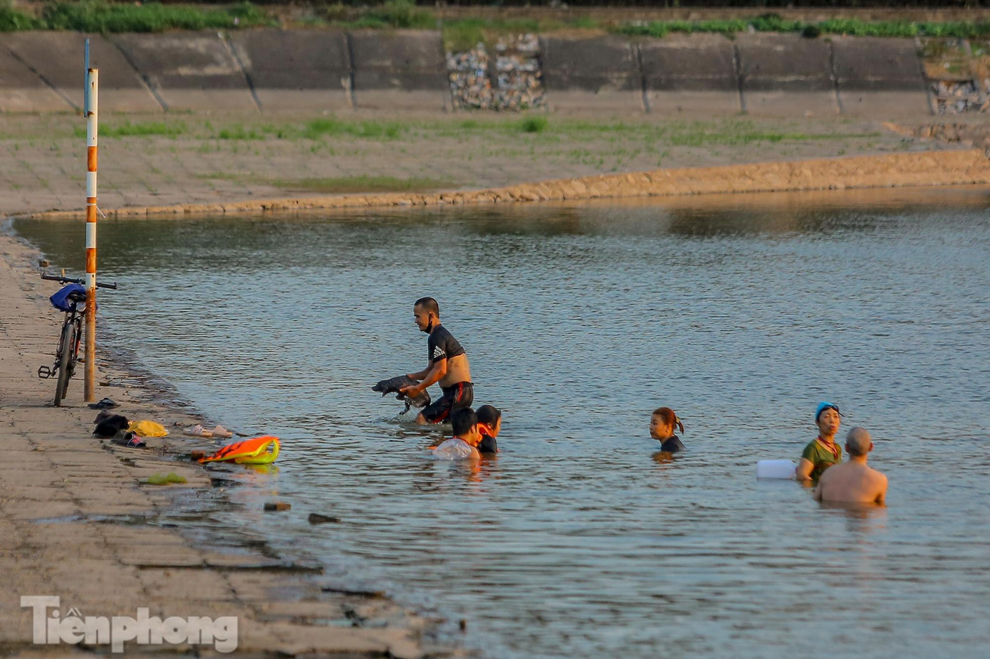 Vào những ngày nắng nóng gay gắt đầu mùa, nhiều người còn tụ tập, bơi lội để giải nhiệt bất chấp tình hình dịch COVID-19 diễn biến phức tạp.
