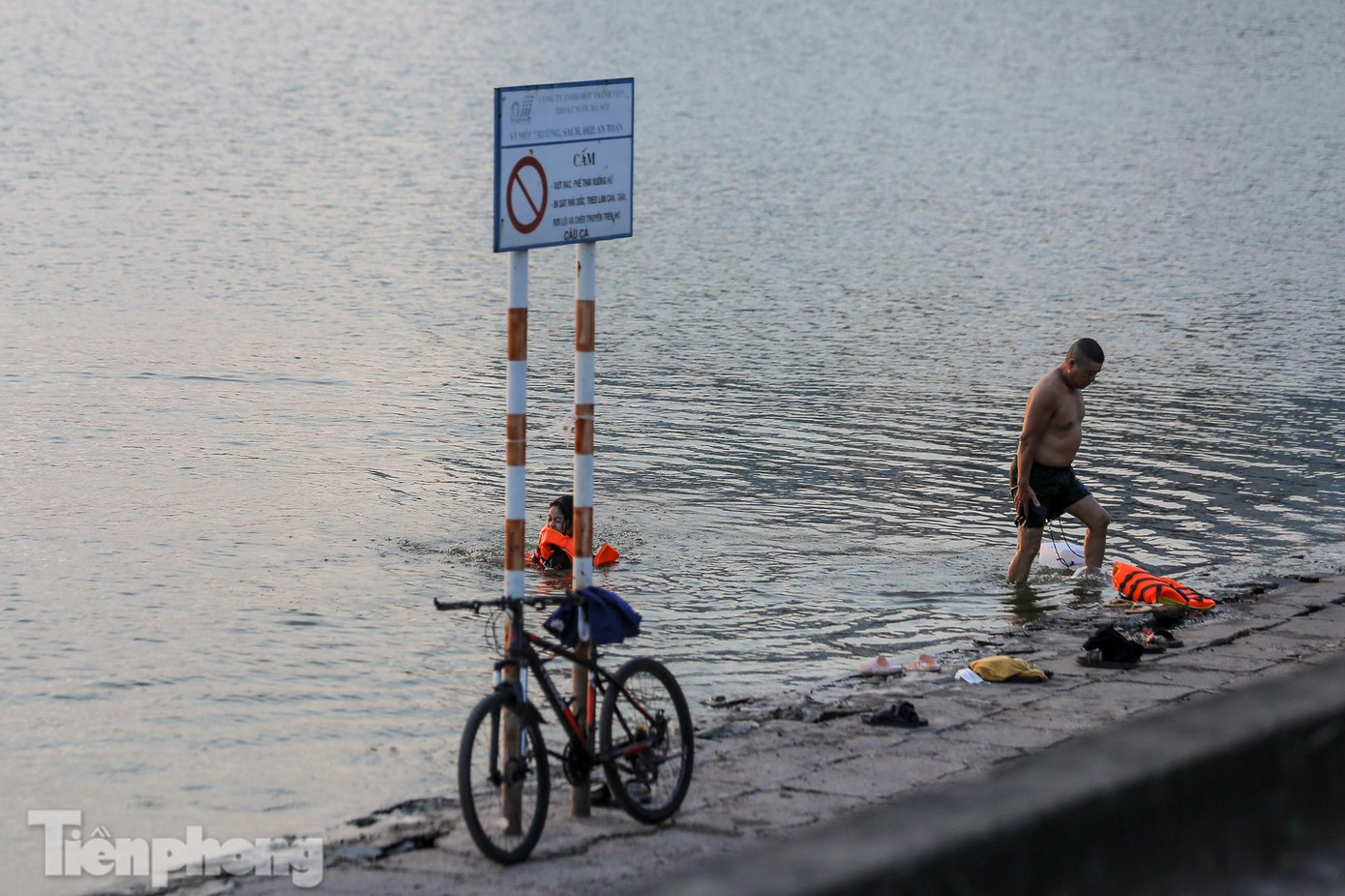 Tuy có biển cấm bơi lội trên hồ nhưng người dân vẫn tụ tập để bơi giải nhiệt.