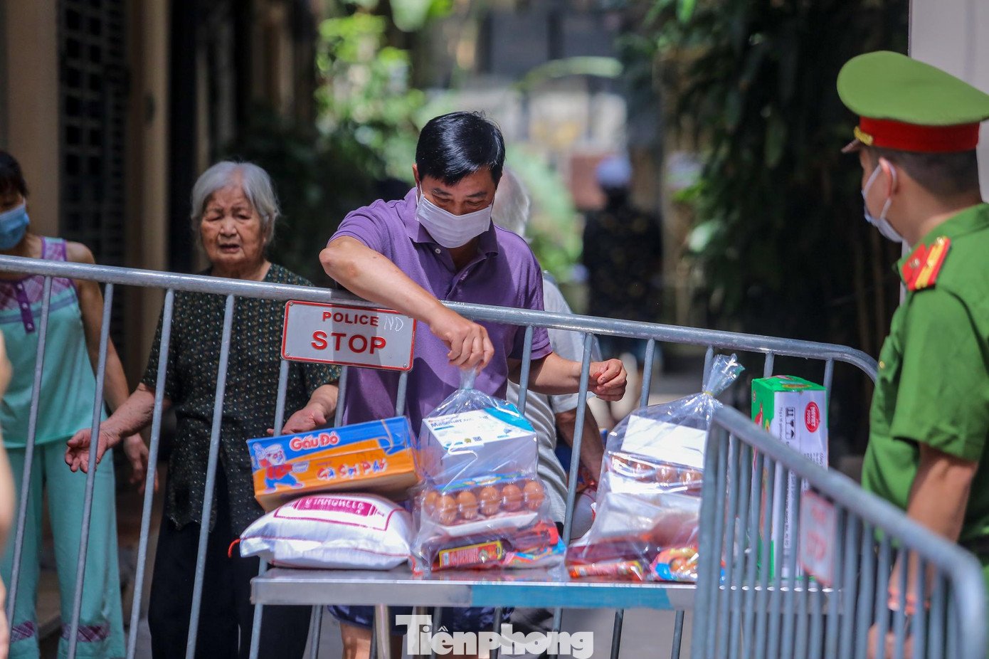 Người dân nhận đồ tiếp tế từ chiếc bàn được đặt sẵn.