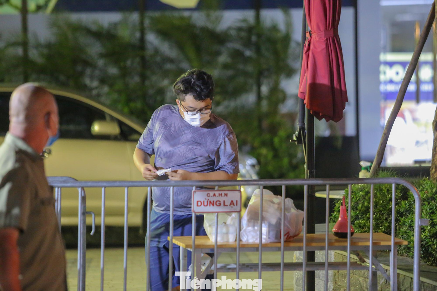 Người thân chuyển đồ cho những người bên trong qua chiếc bàn được đặt cạnh hàng rào.