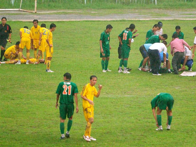 Lãnh đạo hai đội bóng và nhân viên y tế chăm sóc hai cầu thủ bị sét đánh. Ảnh: Dương Thu