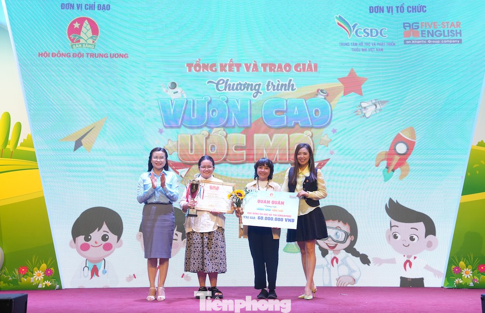 Chị Nguyễn Phạm Duy Trang - Bí thư T.Ư Đoàn, Chủ tịch Hội đồng Đội T.Ư (ngoài cùng bên trái) trao giải Nhất cho em Hà Thúc Chapa, lớp 7A3, trường THCS Phú Mỹ, quận Bình Thạnh, TPHCM