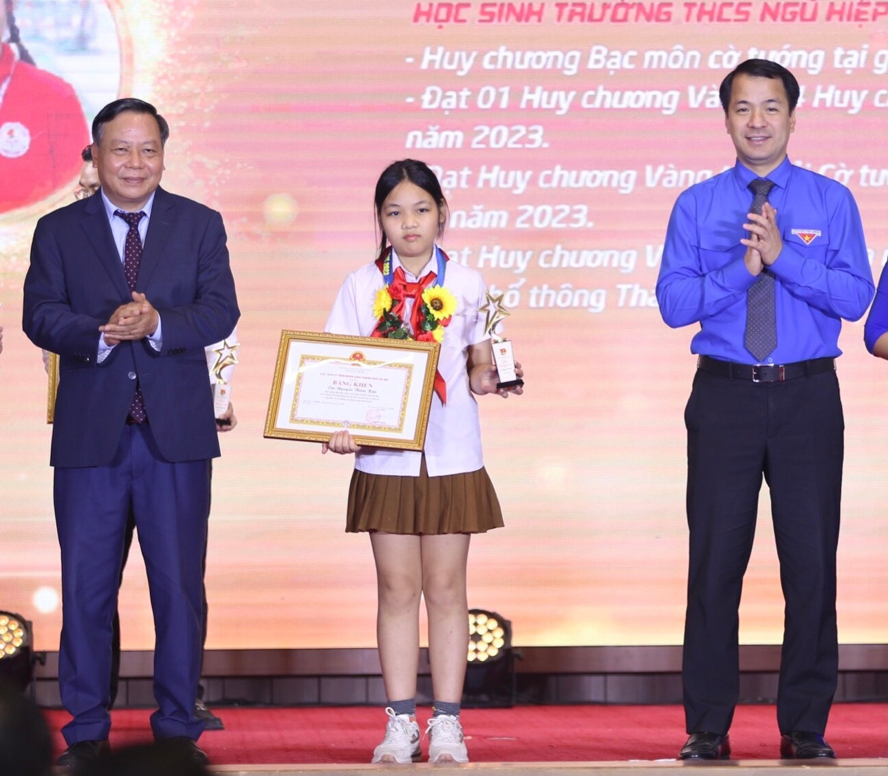 Bí thư T.Ư Đoàn Ngô Văn Cương (bên phải) và Phó Bí thư Thành ủy Hà Nội Nguyễn Văn Phong trao tặng danh hiệu Gương mặt trẻ Thủ đô tiêu biểu năm 2023 cho em Nguyễn Thiên Kim