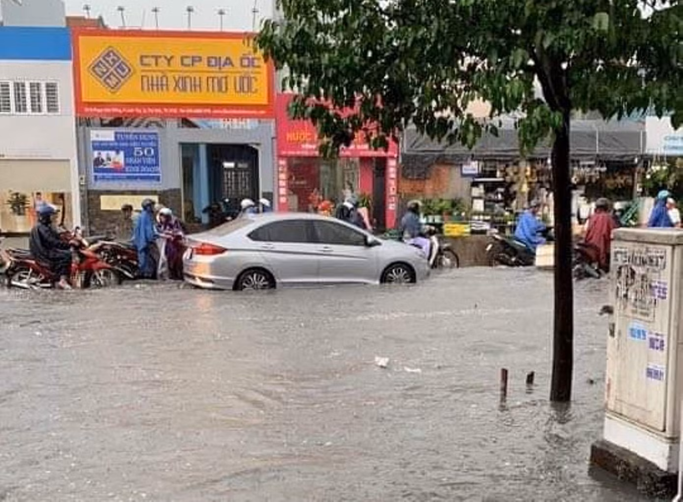 Nước chảy xiết cuốn trôi xe máy trong cơn mưa lớn ở Sài Gòn ảnh 1