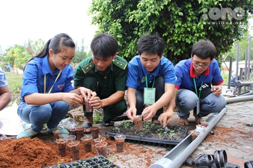 Nhóm bạn đang hướng dẫn bộ đội biên phòng trồng và lắp đặt giàn rau