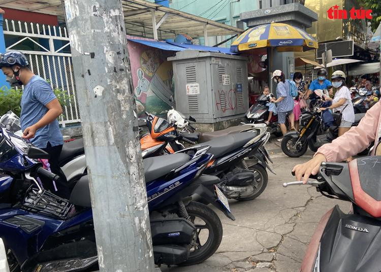 Nhiều phụ huynh không muốn tốn tiền đành phải đỗ xe ở khu vực khác trước cổng trường.