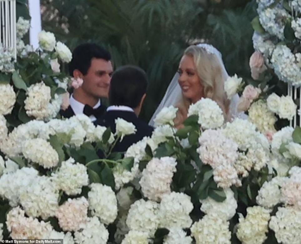 Tiffany và hôn phu kém 4 tuổi trao lời thề nguyện trước sự chứng kiến của chủ hôn, gia đình và bạn bè. Đôi vợ chồng mới quen nhau vào năm 2018. Tháng 1/2021, người thừa kế tập đoàn tỷ USD quỳ xuống cầu hôn bạn gái hơn tuổi bằng nhẫn kim cương 13 carat trị giá 1,2 triệu USD trong Vườn Hồng của Nhà Trắng ngay trước khi nhiệm kỳ Tổng thống của ông Trump kết thúc. Ảnh: Daily Mail.