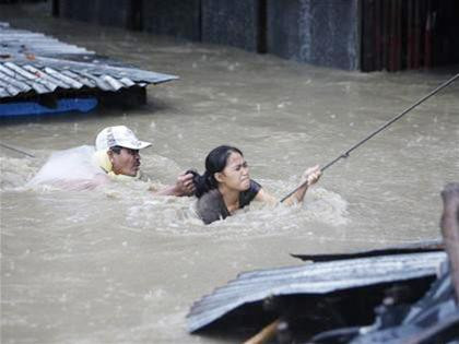 Một phụ nữ đang cố gắng thoát thân với trợ giúp của lực lượng cứu trợ ở Manila