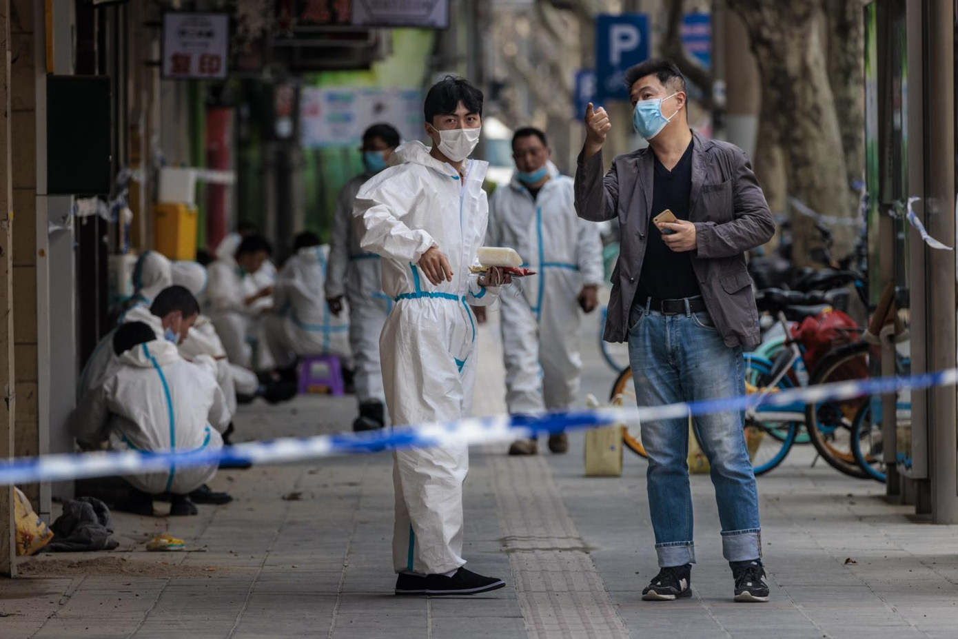 Nhân viên y tế mặc đồ bảo hộ đứng bên ngoài một toà nhà bị phong toả ở Thượng Hải ngày 14/3. Ảnh: EPA-EFE Nhân viên y tế mặc đồ bảo hộ đứng bên ngoài một toà nhà bị phong toả ở Thượng Hải ngày 14/3. Ảnh: EPA-EFE