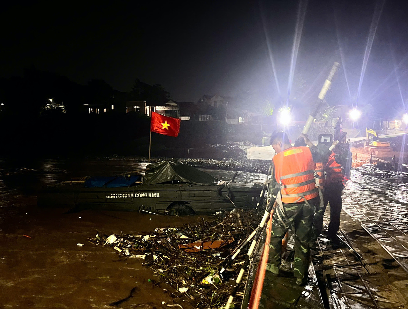 Cùng với đó, cán bộ, chiến sĩ thức xuyên đêm dọn rác bám vào thân cầu phao. Cùng với đó, cán bộ, chiến sĩ thức xuyên đêm dọn rác bám vào thân cầu phao.