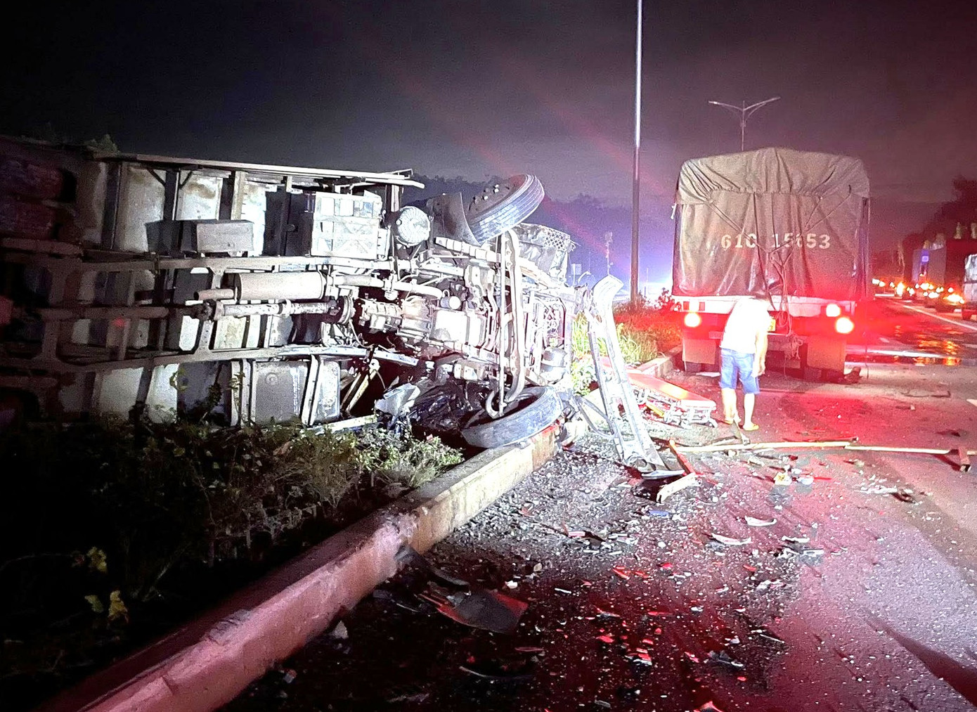 Cú tông mạnh khiến một xe tải chưa rõ biển số bị lật ngang nằm trên dải phân cách. Còn cabin xe tải còn lại thì bẹp dúm, tài xế tử vong. Cả hai xe đều hư hỏng nặng.