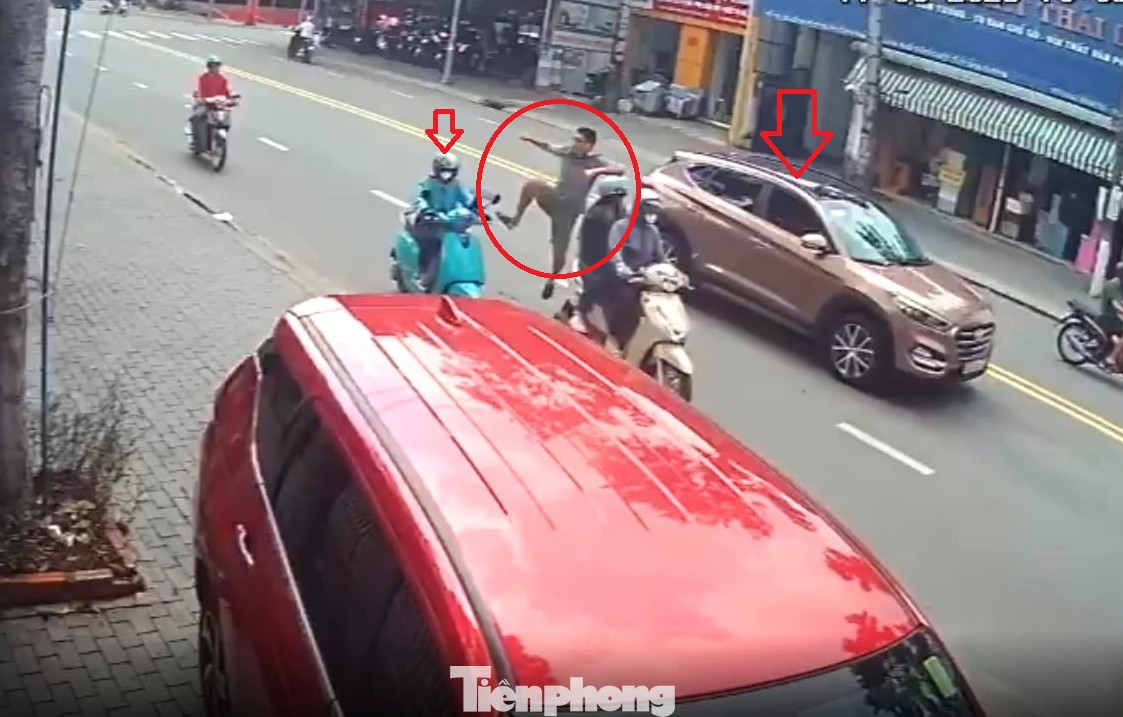 Tài xế ô tô dùng chân đạp vào xe máy đang chạy trên đường (Ảnh: cắt từ clip)