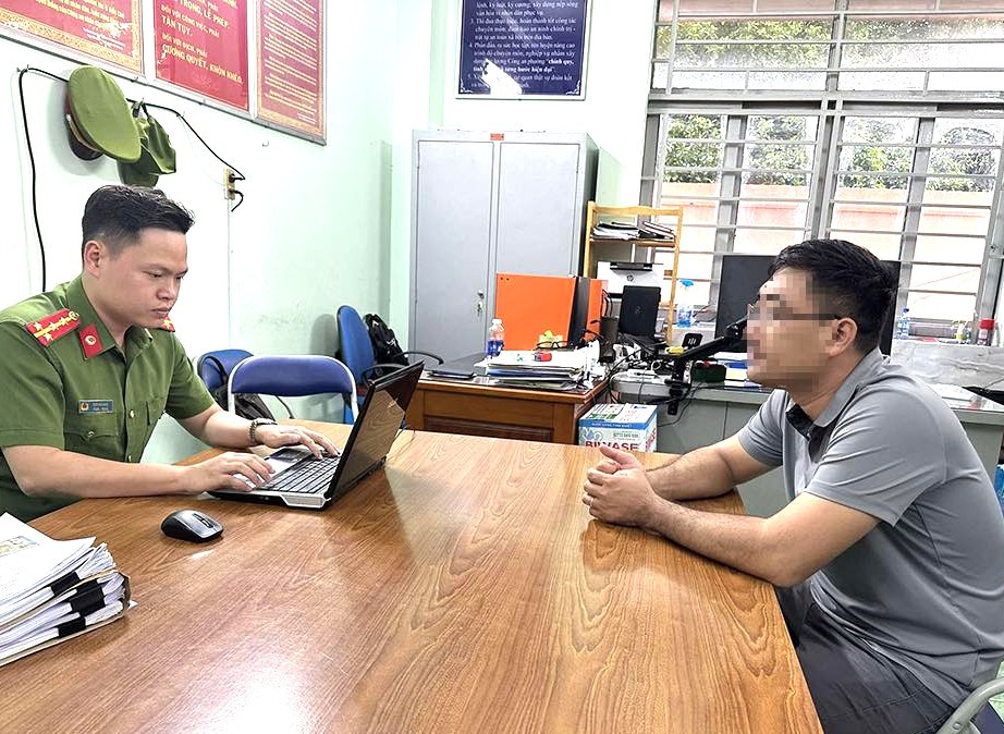 Người đàn ông có hành vi đánh người (bìa phải) làm việc với cán bộ công an