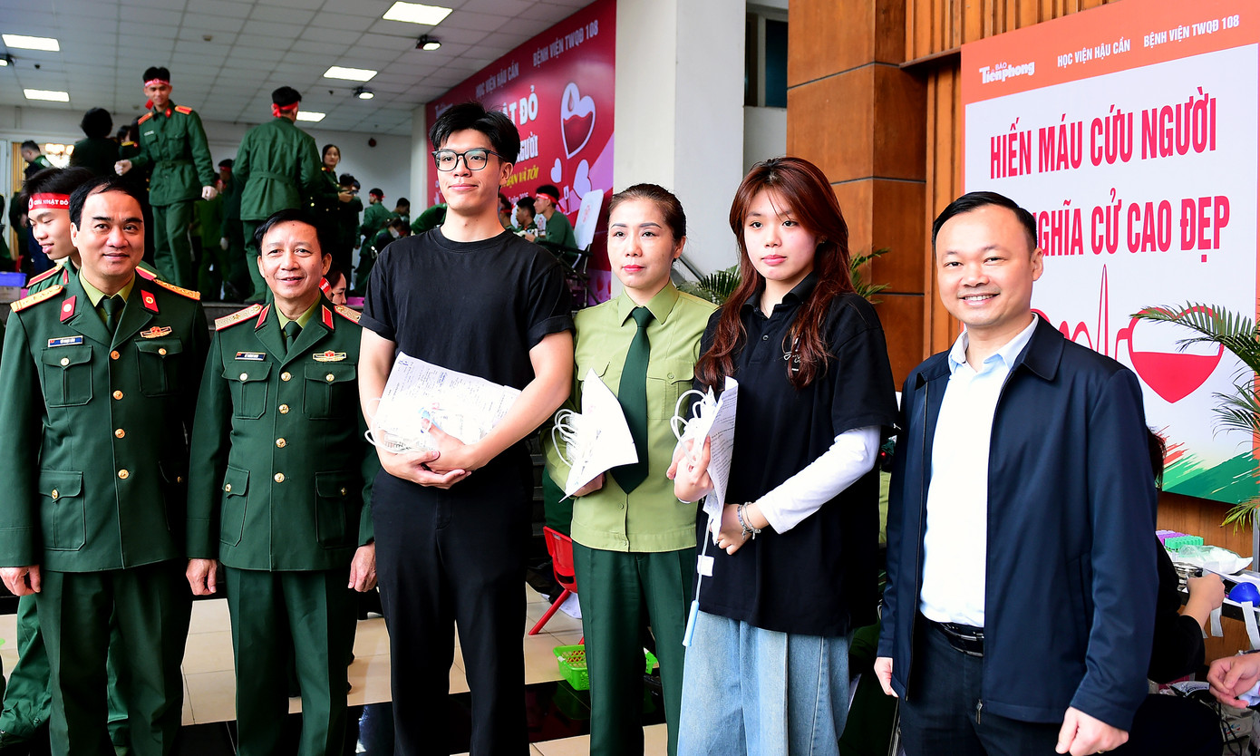 Ban Tổ chức thăm hỏi, động viên và chụp ảnh cùng ba mẹ con chị Phạm Thu Trang - cán bộ công tác tại Học viện Hậu cần, tham gia hiến máu tại chương trình.