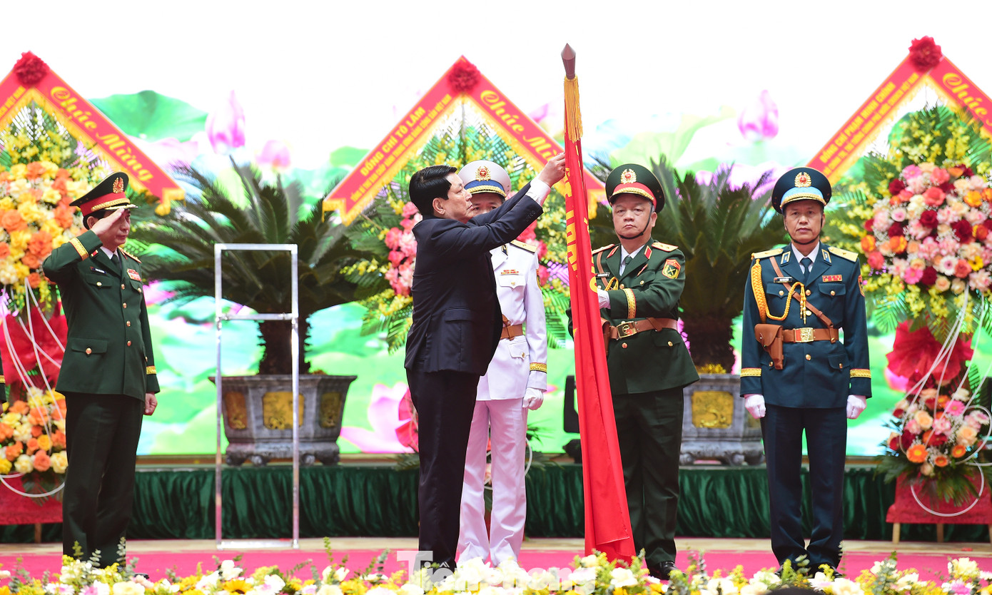 Chủ tịch nước Lương Cường gắn Huân chương Hồ Chí Minh lên cờ truyền thống của Dân quân tự vệ Việt Nam tại Lễ kỷ niệm 90 năm Ngày truyền thống Dân quân tự vệ. Ảnh: Xuân Tùng