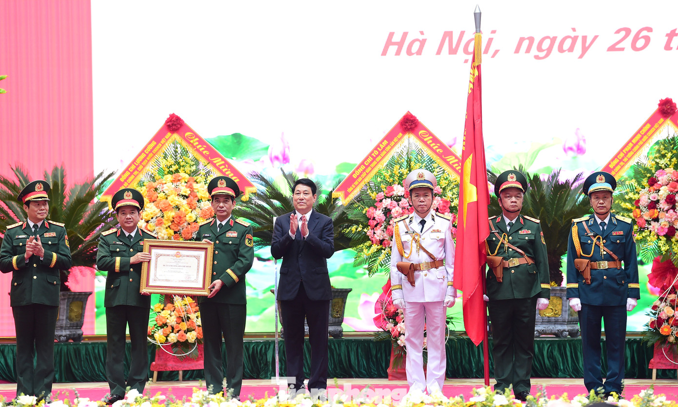 Chủ tịch nước Lương Cường gắn Huân chương Hồ Chí Minh lên cờ truyền thống của Dân quân tự vệ Việt Nam tại Lễ kỷ niệm 90 năm Ngày truyền thống Dân quân tự vệ. Ảnh: Xuân Tùng