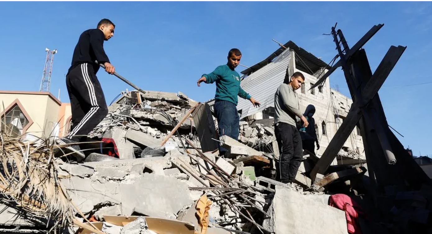 Người dân ở thành phố Khan Younis đứng trên những đống đổ nát (Ảnh: Reuters). Người dân ở thành phố Khan Younis đứng trên những đống đổ nát (Ảnh: Reuters).