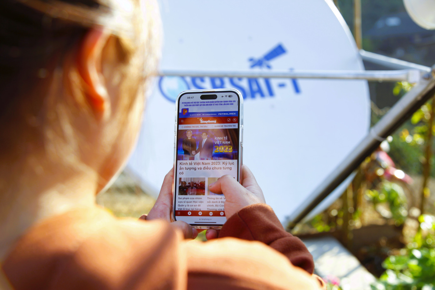Dân bản chưa từng có sóng Interrnet nay có thể vào mạng. Trong ảnh, một cô gái trong bản đọc báo Tiền Phong trên điện thoại thông minh.