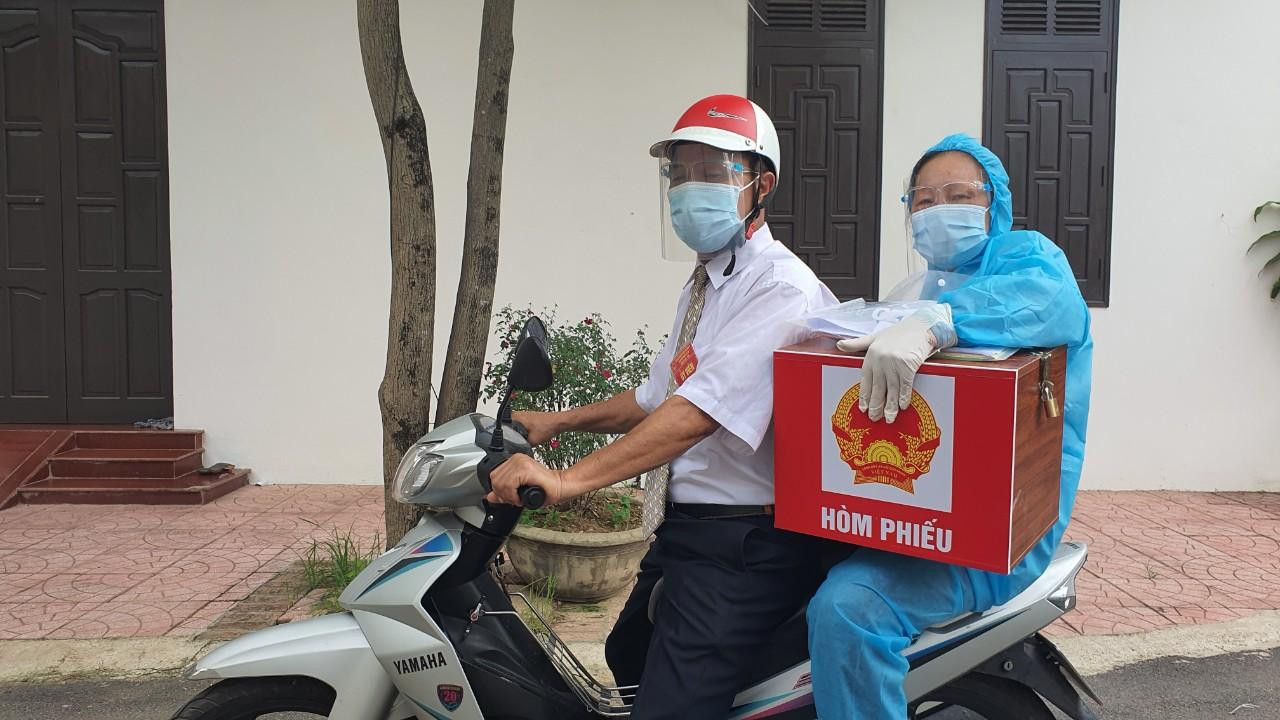 Tổ công tác mang hòm phiếu phụ tới nhà người phải cách ly. Tổ công tác mang hòm phiếu phụ tới nhà người phải cách ly.