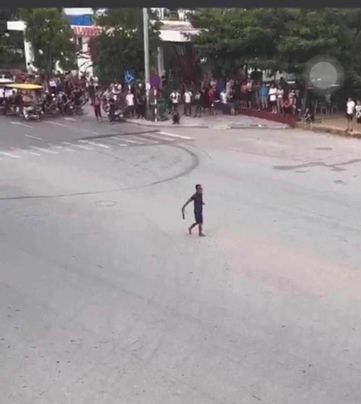 Đối tượng dùng hung khí múa giữa ngã tư đường Hồ Xuân Hương. Ảnh cắt từ clip