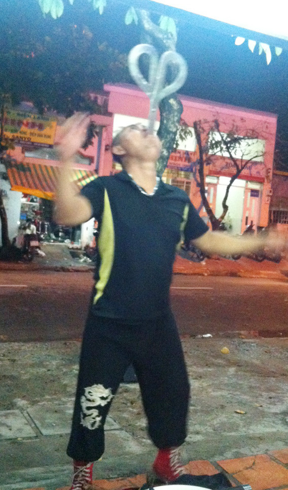 Một “nghệ sĩ” nuốt kiếm biểu diễn ở quán nhậu tại quận 7, TPHCM. Ảnh: L.N