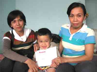 Đại diện Báo Tiền Phong (trái) và chị Phạm Thị Phước với cháu Phạm Văn Thuận. Ảnh H. V