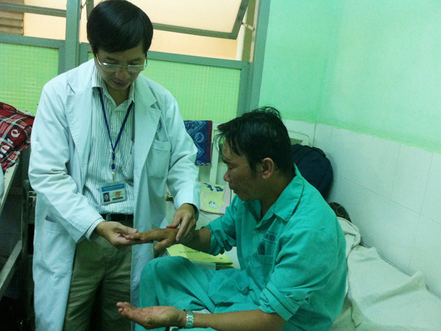 Bác sĩ Cao Văn Thịnh khám cho bệnh nhân Mã Huỳnh Đ. để chuẩn bị phẫu thuật cắt bàn tay. Ảnh: L.N