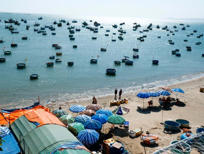 Bãi biển Mũi Né trong xanh với nhiều thuyền thúng của ngư dân.